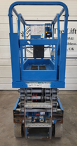 Rear of the Genie GS1930 scissor lift: platform deck with guardrails, decal panel and stacked scissor arms