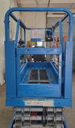 Platform deck of the Genie GS1930 scissor lift: blue steel floor, guardrails and instruction decals