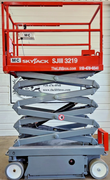 Red Skyjack SJIII 3219 electric scissor lift, side view, scissor stack partly raised, platform guardrails