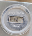 Skyjack hour meter set into the machine frame, dusty face with a partly legible hour reading