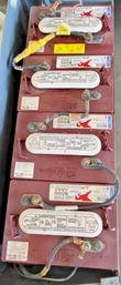Four red Trojan deep-cycle batteries in the lift's battery tray, terminals cabled together