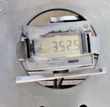 Digital hour meter set into the machine's gray body panel, LCD display showing accumulated run hours