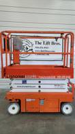 Orange and white Snorkel S3219E electric scissor lift, stowed, side view