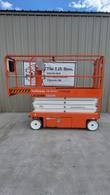 Orange 2019 Snorkel S3226E electric scissor lift, stowed, side view in front of the Lift Bros sign