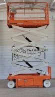 Orange Snorkel S3226E scissor lift with the platform raised high, side view of the extended scissor stack and lift cylinders