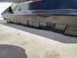 Flail mower deck's lower edge with the row of black rubber guard flaps along the bottom