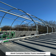 Galvanized steel arch frame on a container roof before the fabric cover goes on, captioned 20x40 frame installation