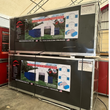 Two crated Covermore 21x40 dual-truss shelter kits stacked, printed spec banners and shipping labels