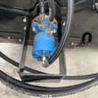 Mower King box broom's blue hydraulic drive motor and braided hoses on the black steel frame