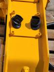 SDCH680 hydraulic hammer's yellow top plate with two rubber-booted hydraulic ports