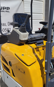 SDLE20 mini excavator pilot joystick and armrest console beside the wrapped seat, above the yellow engine cowl