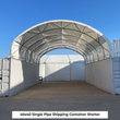 White single-pipe arch shelter spanning two white shipping containers, open on both ends, seen from the front