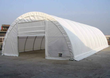 White PVC fabric storage building with rounded roof, open end wall and roll-up door