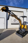 AGT MX12R mini excavator with the boom raised to full height, bucket curled and fixed thumb, canopy and backfill blade