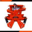 Orange TopCat tree shear, front view: open shear blades, clamp arms, hydraulic hoses and quick couplers