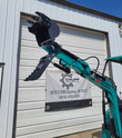 QK16R mini excavator boom raised with the digging bucket and hydraulic thumb open, AGT Industrial decal on the arm