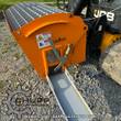 Landhonor cement mixer bucket attached to a skid steer, steel grate over the drum, discharge chute open; example photo
