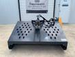 Gray hydraulic landscape rake front-on, twin slotted hopper decks, center mount with spring linkage, dense raking teeth below