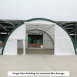 White fabric building with green trim, front and side doors open, on a concrete lot
