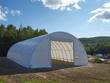 White PVC hoop building with open front, cover panel rolled up above the doorway