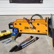 Wolverine 750 hydraulic hammer with spare chisel bits, tool box, and pressure gauge kit