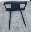JCT double bale spear, front view: black quick-attach frame with two tapered forged tines pointing down