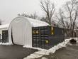 White fabric front wall with center door panel installed on a container shelter, snow on the roof