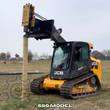 AGROTK 680 post driver on a JCB tracked skid steer, driving a wooden fence post into the ground