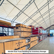 Wooden shipping crates of packaged metal garages and sheds stacked in a dual-truss warehouse
