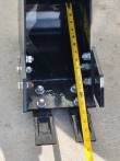 Tape measure down the depth of the trenching bucket, past the 16-inch mark, two teeth at the lip