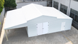 White 42x30 steel garage assembled, ribbed metal roof, open lean-to bay, double doors and side walk door