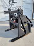 Log grapple with clamp arms raised above the tapered tines, twin cylinders on the quick-attach plate