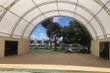 Dual truss container shelter interior: white PVC canopy on steel arches spanning two containers over a wood deck