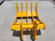 Yellow excavator rake front-on: five tines with bolted tips above a serrated back plate and pin bosses