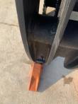 Grapple bucket tine end with an orange bolt-on tooth, serrated grapple arm above