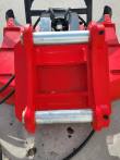 Top of the red Captok disc mulcher: twin polished mounting pins, hydraulic motor and spiral-wrapped hoses