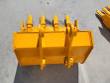 Yellow excavator bucket from above, four bolt-on teeth and twin pin bosses on the mount