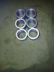 Six machined 1018 steel cylinder pin bushings, end-on view