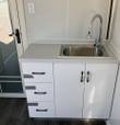 Kitchenette with stainless steel sink, chrome pull-down faucet and white cabinet with three drawers