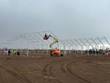 Steel truss frame of a fabric building under construction, boom lift and crew on site