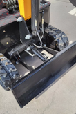 MIVA VA15 black backfill blade and its hydraulic lift cylinder mounted between the rubber tracks