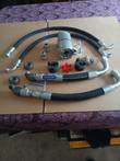 Hydraulic pump kit laid out: gear pump, lovejoy coupler, 1-inch suction hoses with ball valves, pressure hoses