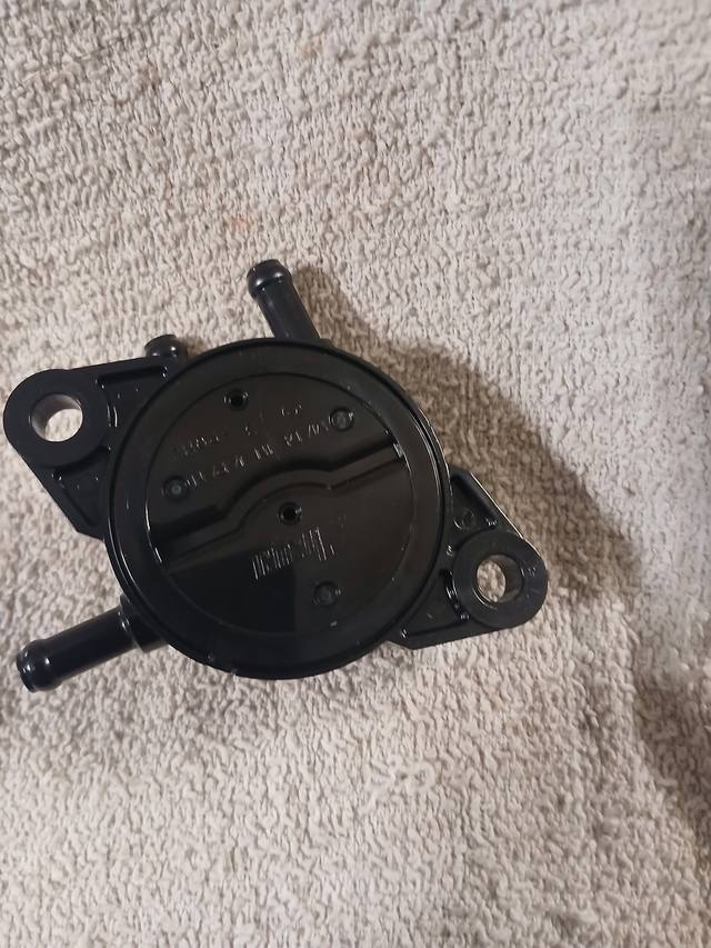 Black fuel pump with three hose barbs and two mounting ears