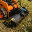 AGT flail mower mounted on an orange skid steer, cutting grass; blue hydraulic drive motor and hoses at the deck