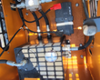 QB-480 mini skid steer engine bay: battery, hydraulic block with quick-connects and wiring