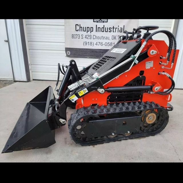 AGT LRT23 mini skid steer, red body with black bucket, rubber tracks and hydraulic lines along the loader arm