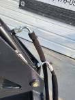 Hydraulic hose with a 90-degree fitting and protective wrap on the log grapple frame