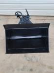 Black hydraulic tilt bucket from the front, deep open shell with tilt coupler and coiled hoses