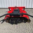 Red disc mulcher, front view of the toothed cutting disc with replaceable teeth and hydraulic hoses