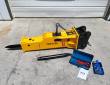 Yellow TOFT750 hydraulic breaker with a spare moil chisel, blue tool box, nitrogen charging kit and manual